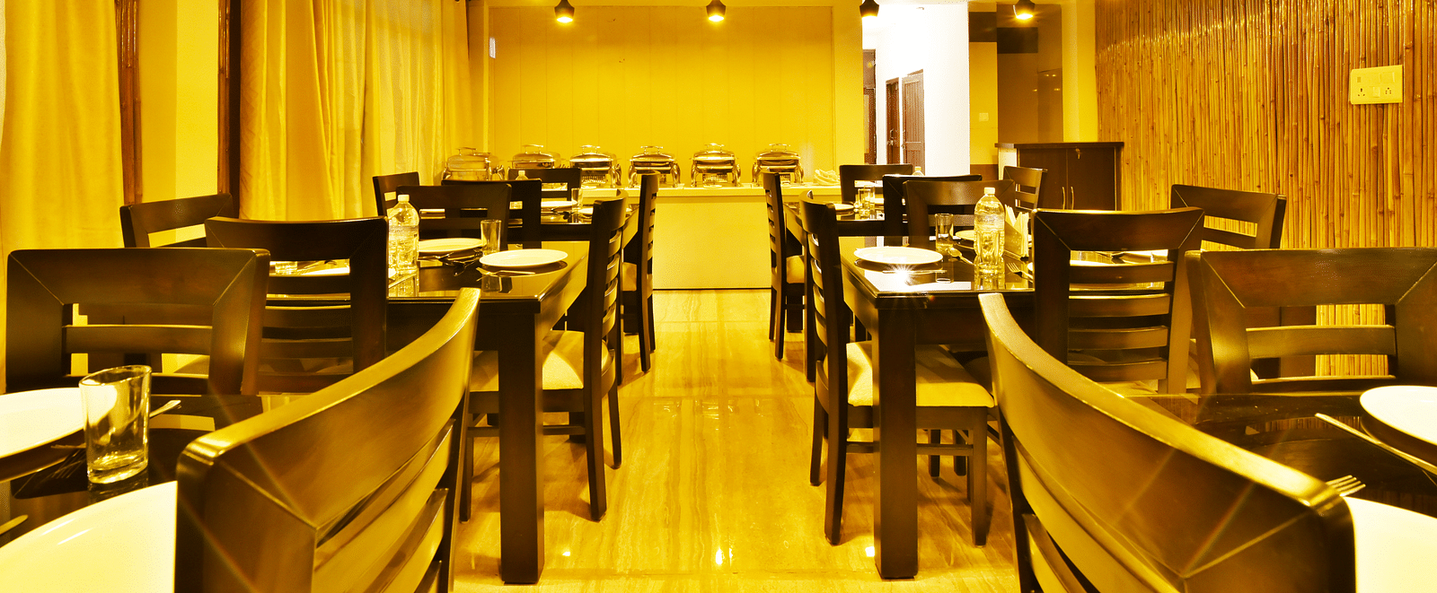 An image of the woodden tables and chairs in the restaurant of the resort | DLS Kapoor Resort Manali