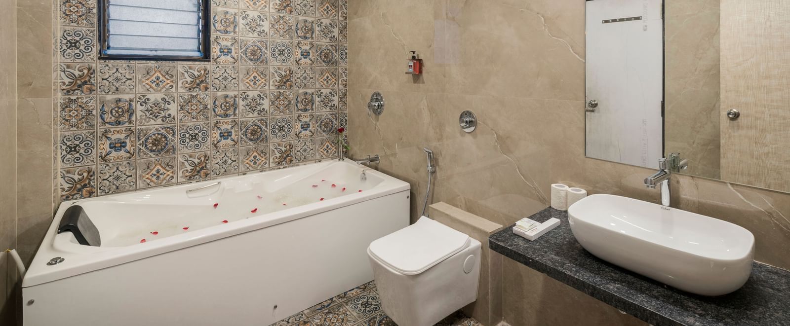 Luxurious bathroom at Emerald Retreat, Tungarli with large jacuzzi bathtub, modern fixtures, and decorative tiles.