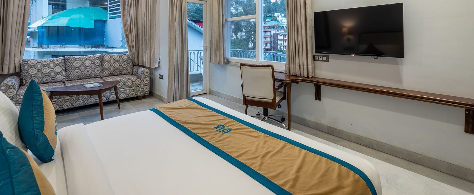 Spring Suite at DLS Spring Valley Resort Dharamshala featuring a kind bed, work desk and chair, TV, sofa and a huge balcony