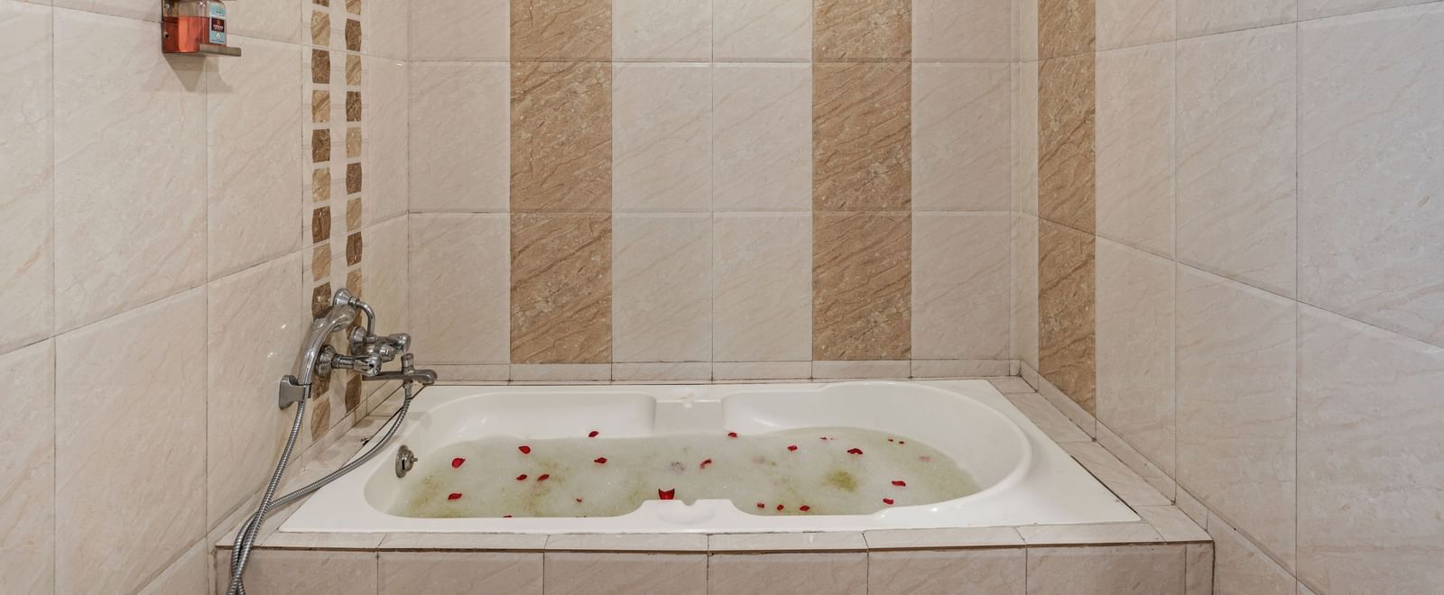 Bathroom featuring a clean modern design with beige tiles and a built-in bathtub with overhead shower at Emerald Retreat, Tungarli.