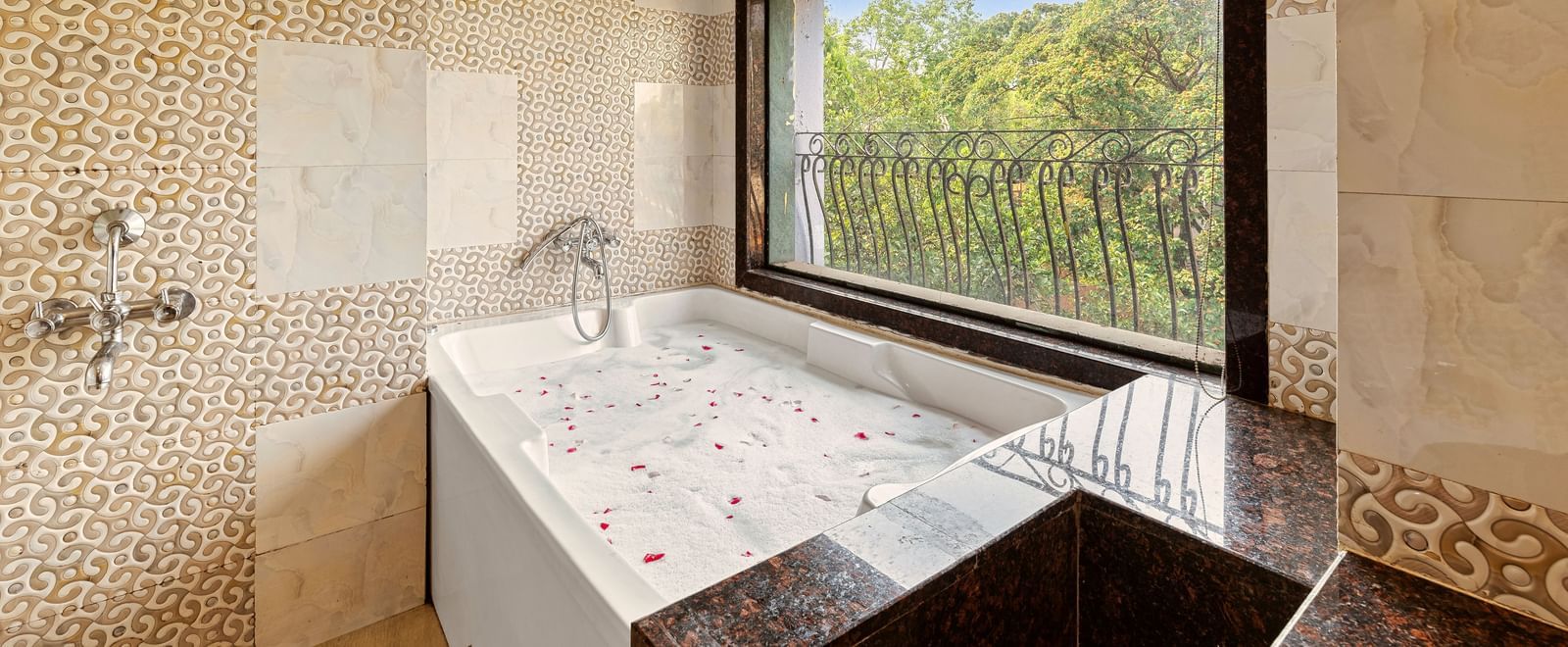 Luxurious bathroom featuring a large bathtub by a window with scenic outdoor views at Mayur Retreat.