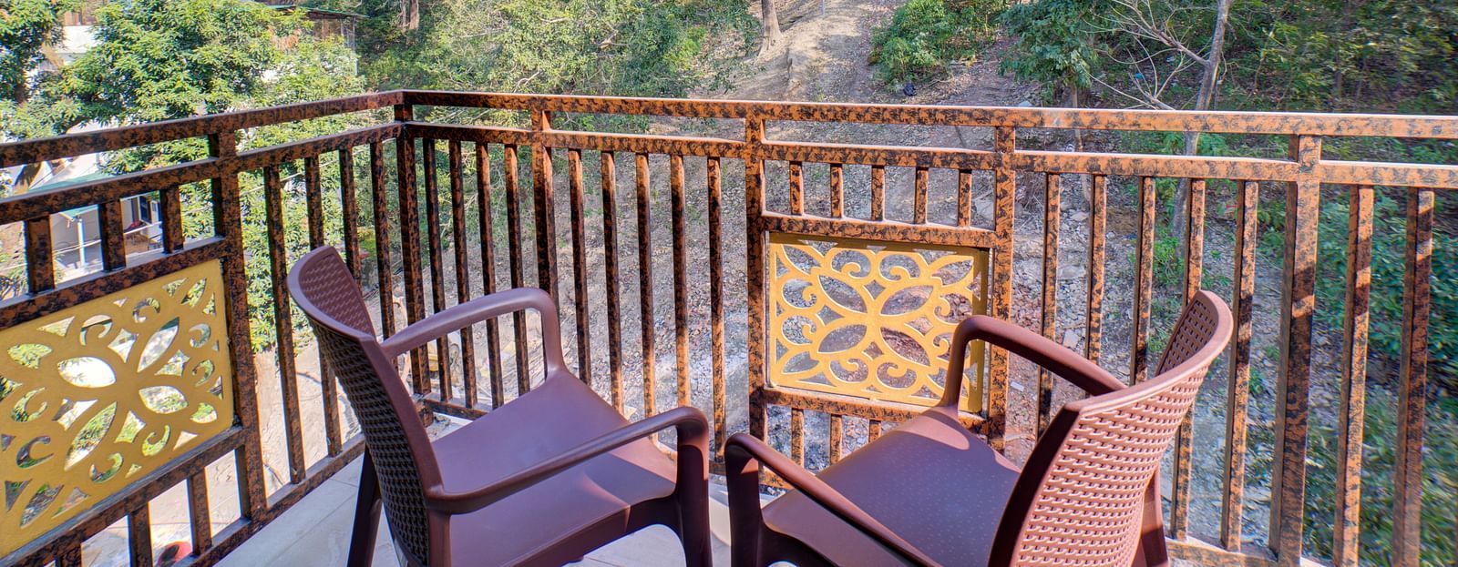 Balcony with outdoor seating overlooking a forest at Bedzzz, Rishikesh
