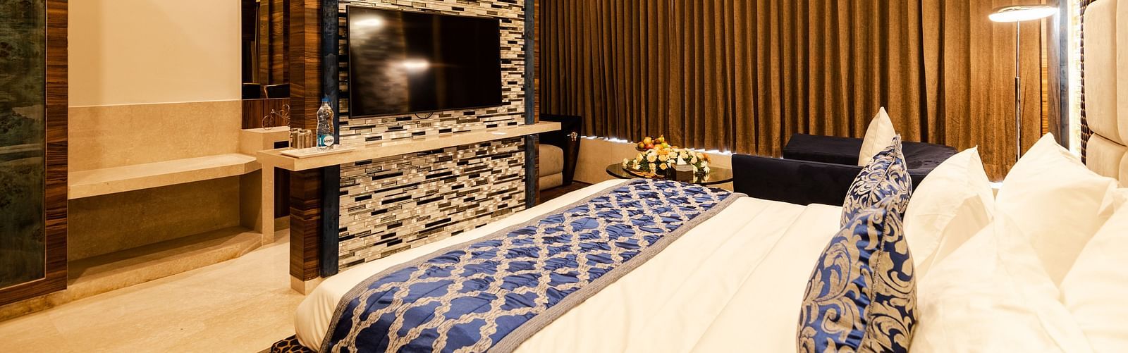 Queen suite decked with a bed and television at Hotel Park Elanza, Coimbatore