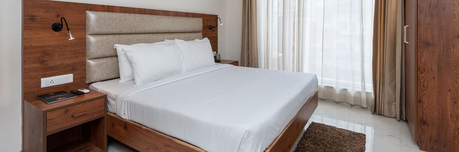 A Deluxe Room featuring a king size bed and a stylish patterned headboard at DLS The Classio