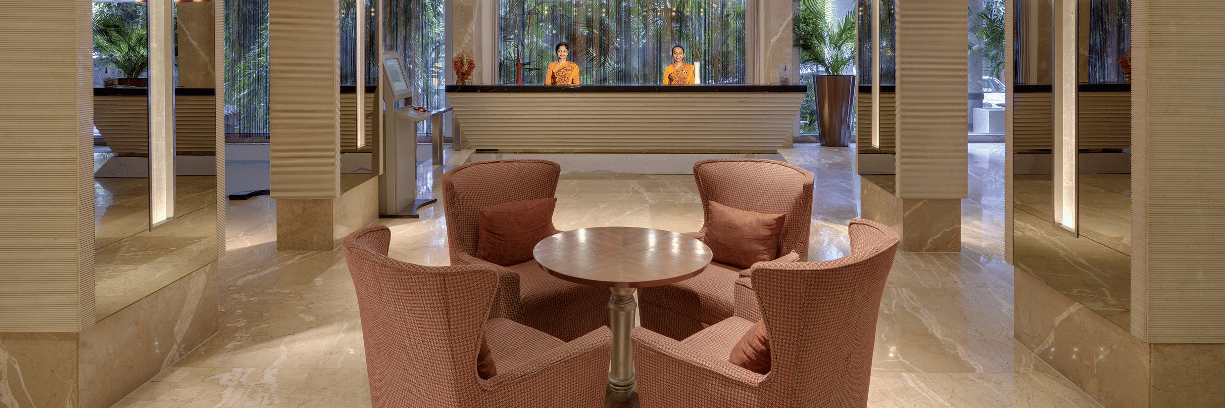  A welcoming hotel lobby with a front desk, comfortable seating, and elegant lighting, possibly at Pride Premier Pune