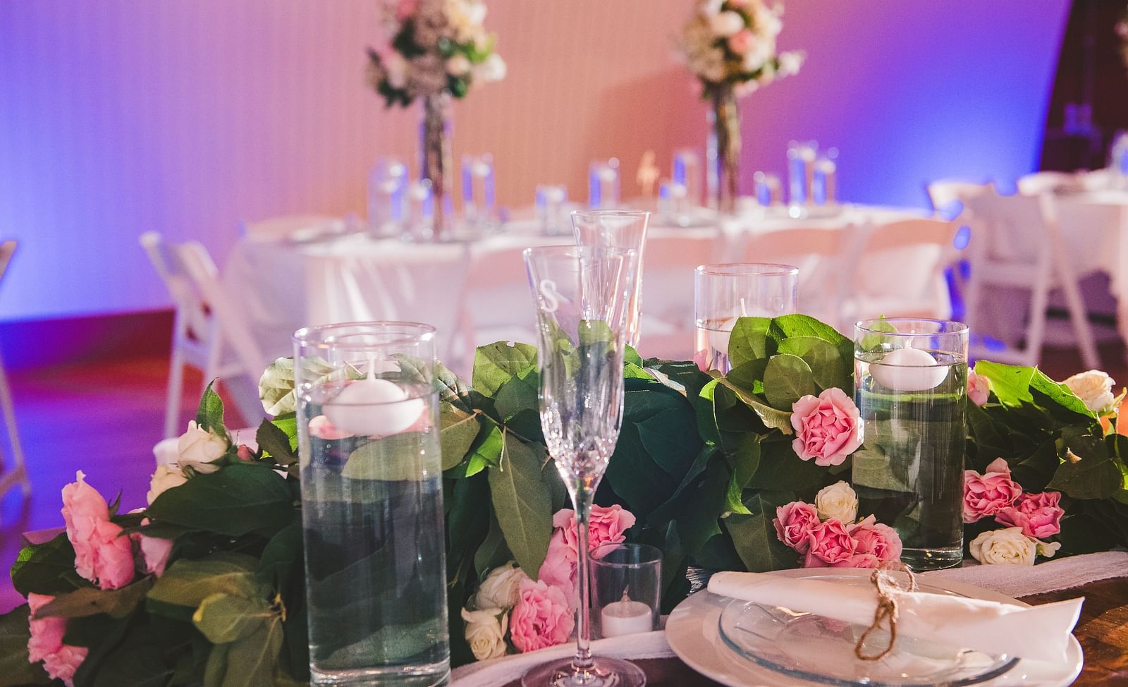 close up image of a table with fresh tulips kept along a champagne glass and white porcelain plates - Historic Tapoco Lodge