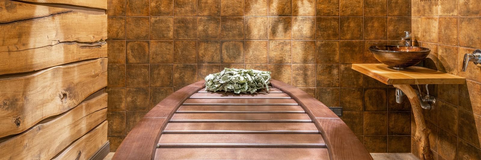 A spa room with wooden interiors showcasing a spa table, side table, and a photo frame.