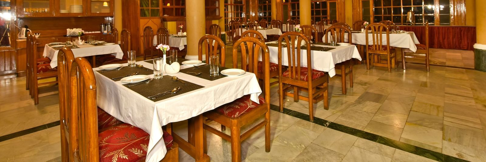 A cosy dining space with tables and chairs at DLS Hillcrest Resort, Shimla.