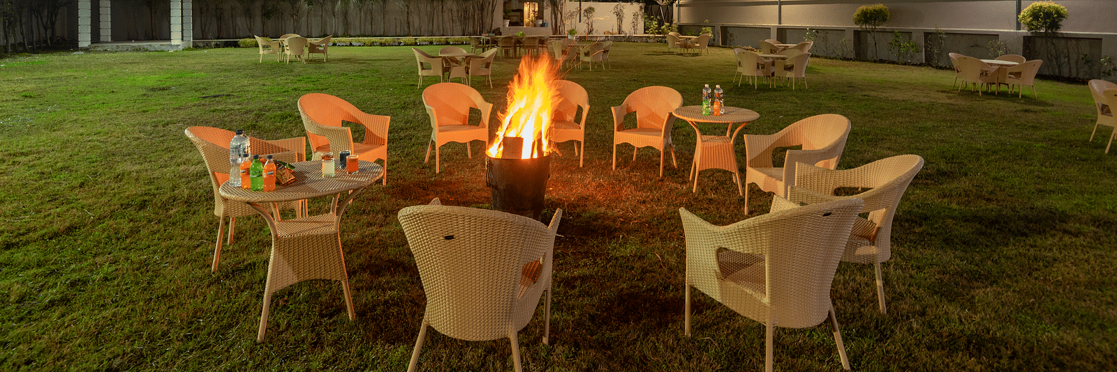 A bonfire with arranged chairs in the lawn at DLS Park Grace, Haridwar.