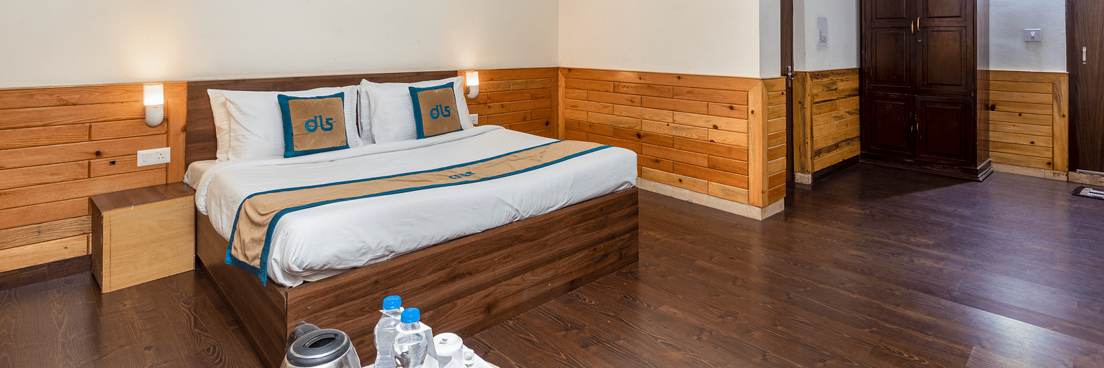 Image of well furnished room featuring a king size bed and a large open space with wooden flooring | DLS Anupam Resort, Dharamshala