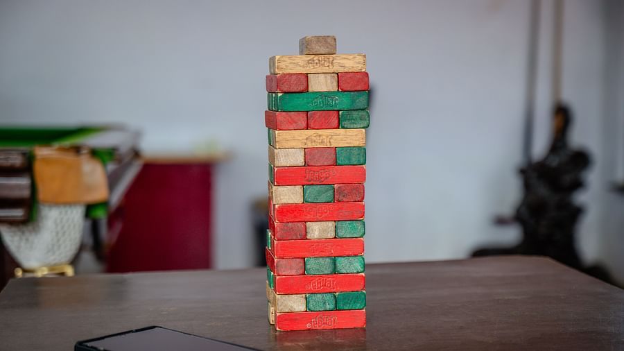 A stack of wooden blocks next to a smartphone on a table | Woodstock Resorts, Coorg