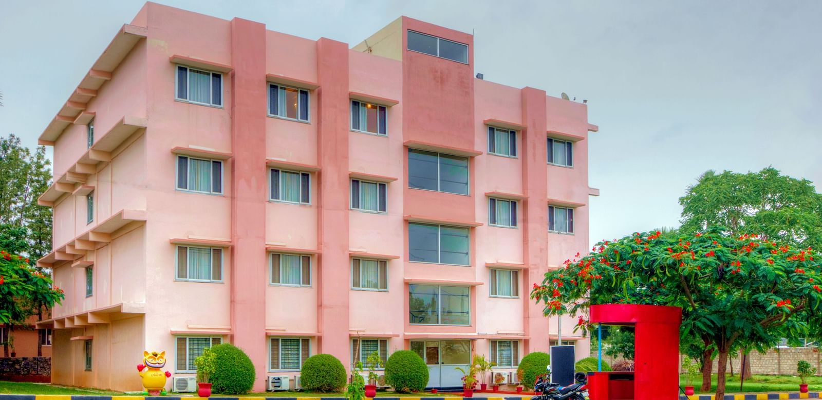 Exterior of Greens Inn with a lawn in front of it - Beautiful Hotel Grounds in Hyderabad.