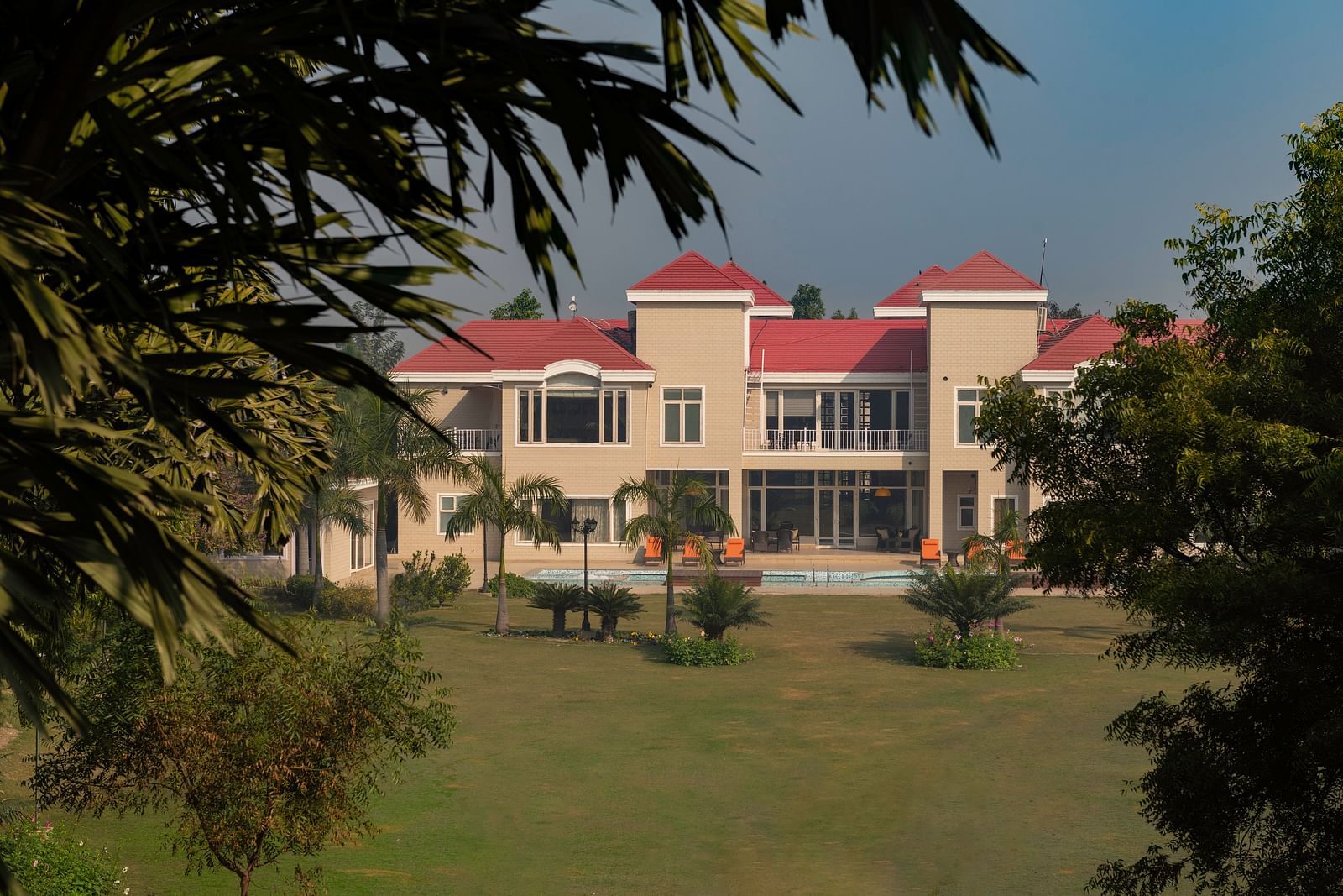 Facade view of BluSalzz Resort with garden and trees in the front.