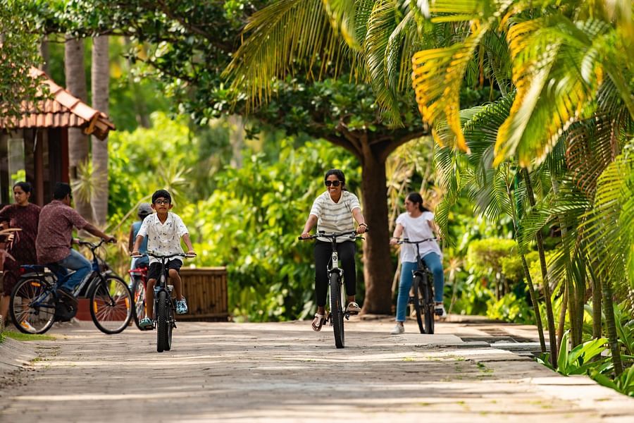 alt-text a group of kids cycling on a stone pathway with trees surrounding it and it is one of the best things to do in Pollachi - Ibex River Resort, Pollachi