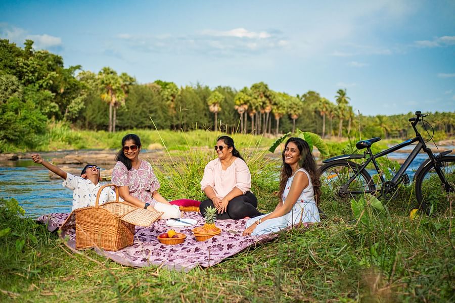 alt-text a group of women having a picnic by river bed - Ibex River Resort, Pollachi