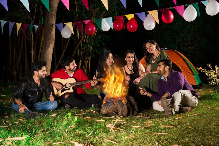 a group of people enjoying themselves at a bonfire