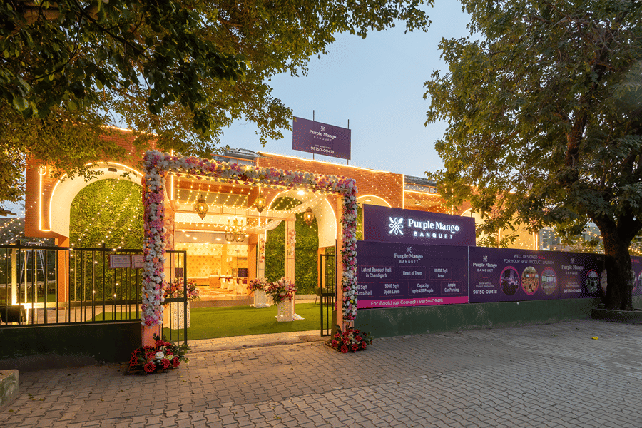 Decorated entrance archway with greenery at dusk at Mango Grove Hotel, Chandigarh.