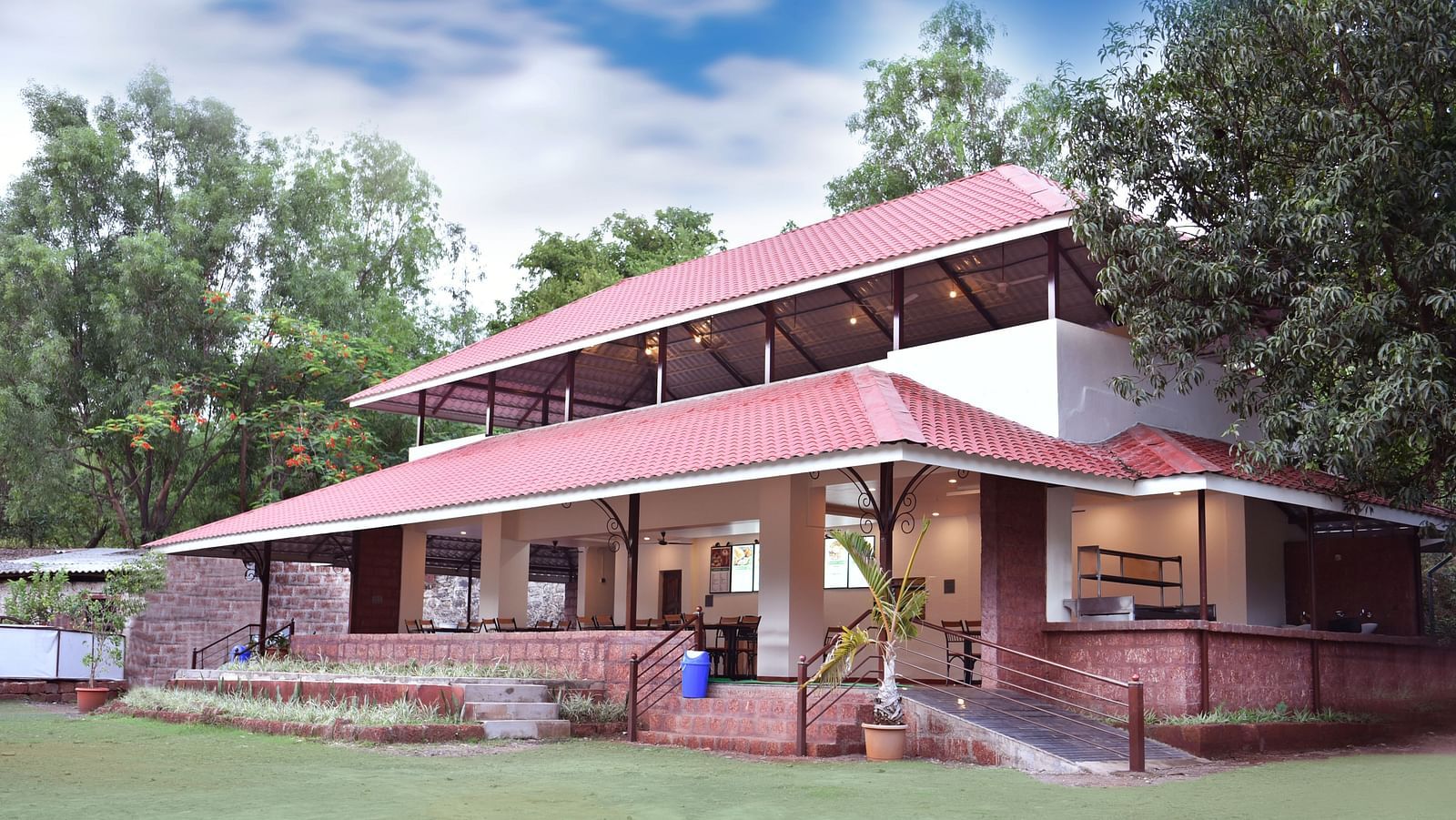 A side view of the restaurant facade at Riverside Inn, surrounded by plants and trees.