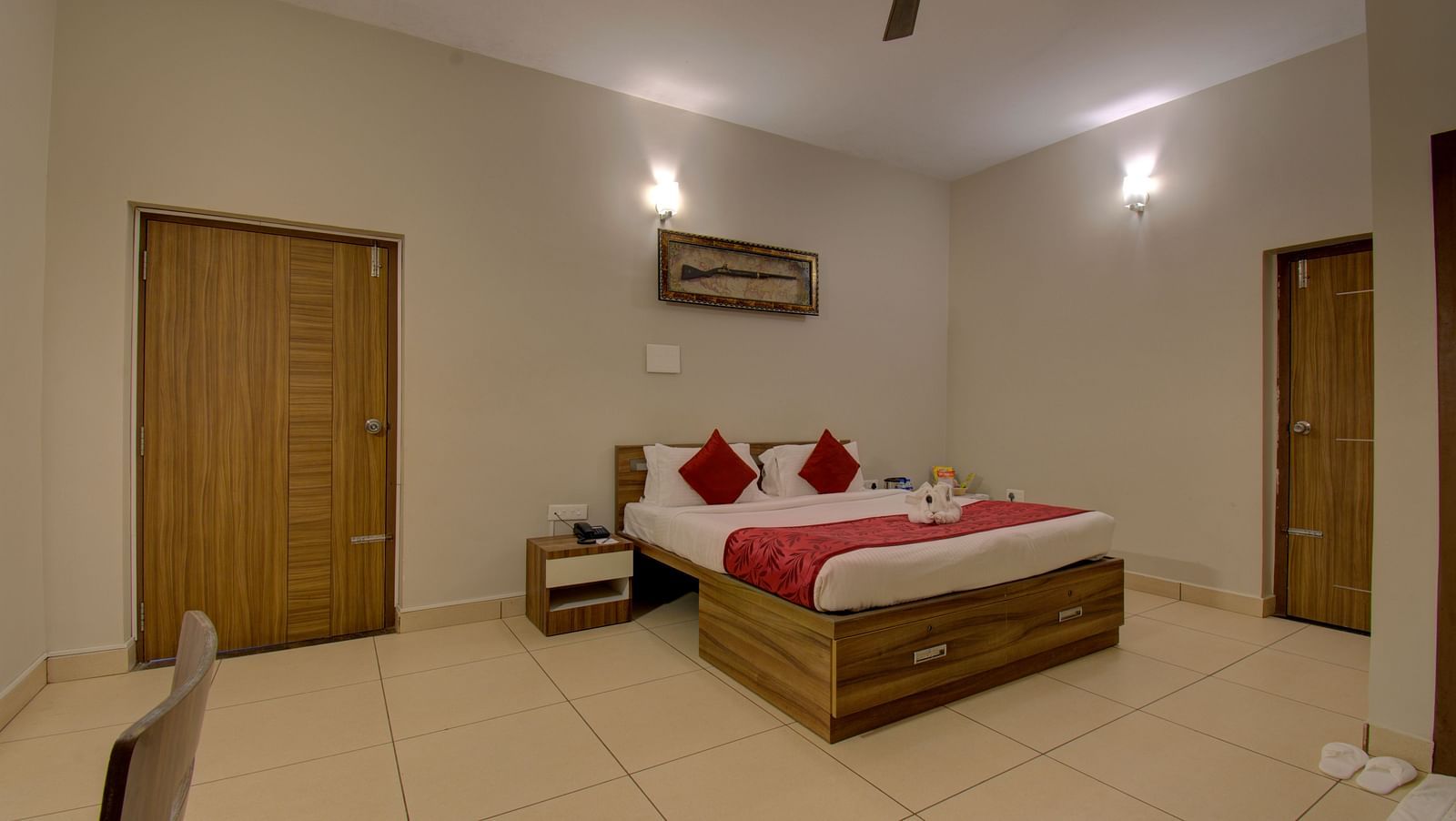 Bedroom with a double bed, side table, tiled floor, ceiling fan and wooden doors | Superior Room | Woodstock Resorts, Coorg