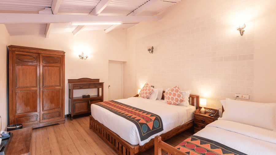 The interiors of the Oxford bedroom with king size bed, wooden floors and white walls - Ibex Resort, Coonoor (Leewood).