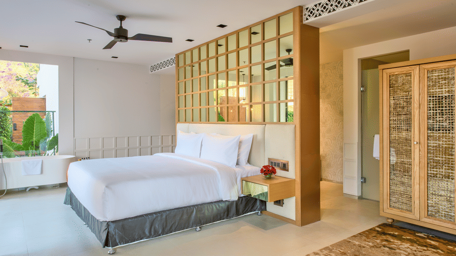Pool Deluxe Villa featuring a plush bed and a nightstand next to it with a flower vase on it at Azaya Beach Resort Goa