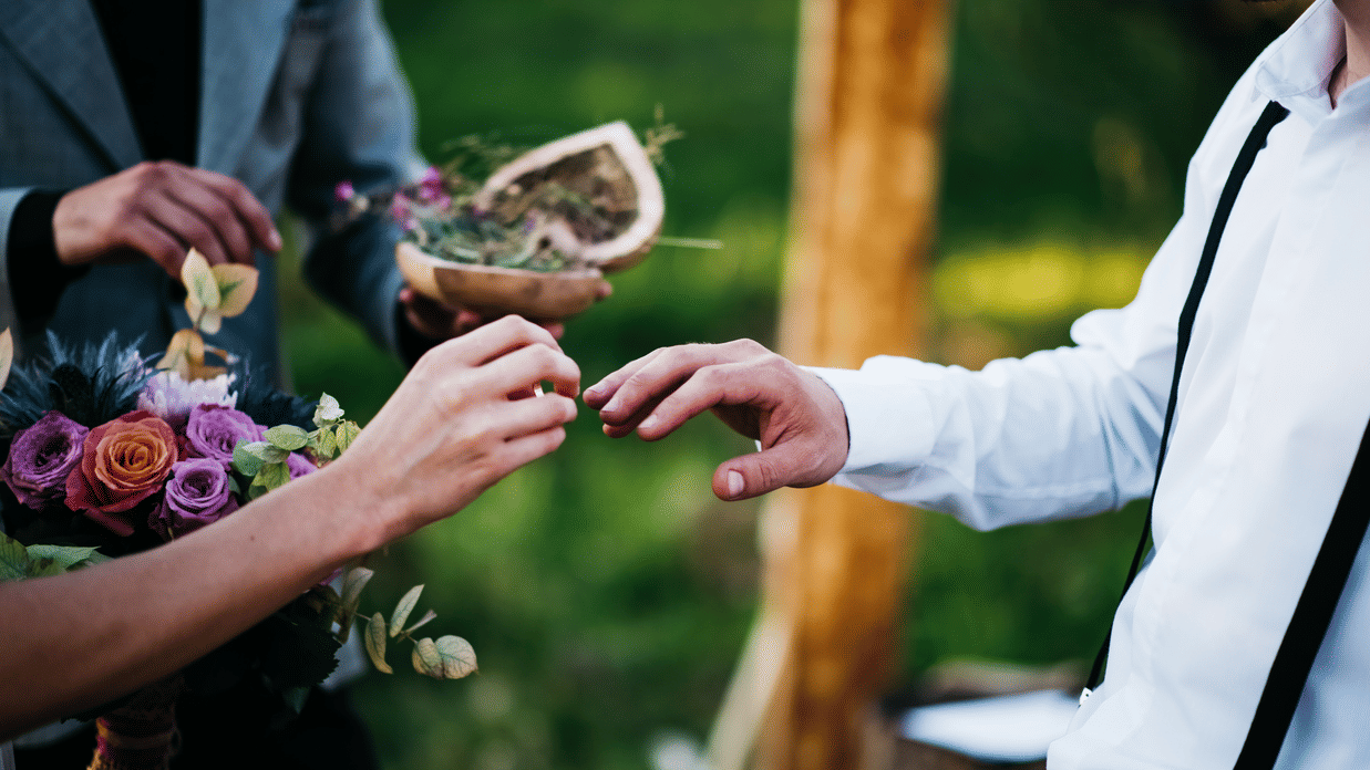 Bride putting a ring on the groom's finger at the wedding