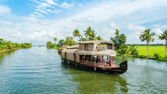A house boat navigating a green waterway between rice paddies under a blue sky.