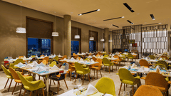 An image of a restaurant with seating arrangement, decorative lighting and items - Pride Elite Phaltan