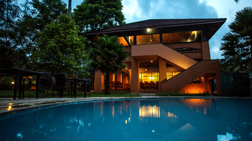 A serene poolside view surrounded by greenery at one of the finest resorts in Thekkady, offering a tranquil retreat at Abad Green Forest, Thekkady.