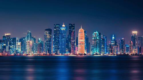 A view of Doha city line at night with the lights reflecting in the water