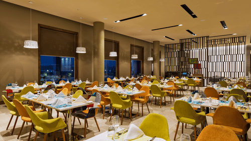 An image of a restaurant with seating arrangement, decorative lighting and items - Pride Elite Phaltan