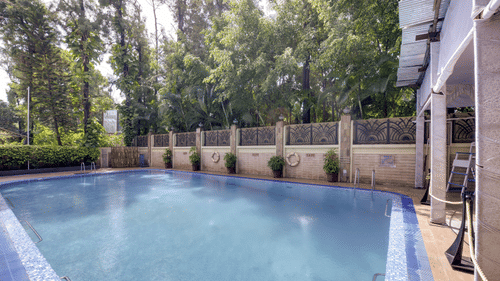 image of swimming pool with clear water on a sunny day at Pride Premier Pune