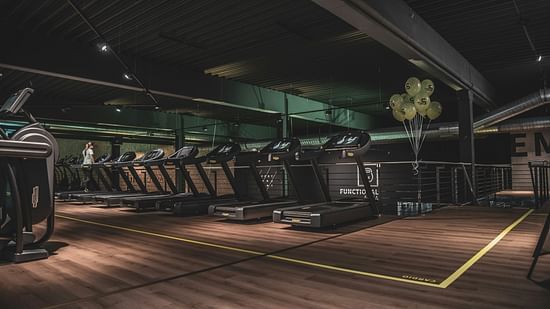 Fitness centre with modern treadmills, wooden floor and ambient lighting