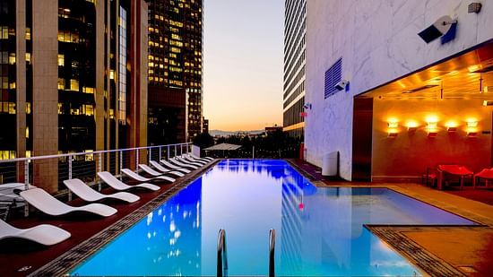 An image of a swimming pool with lounge chairs