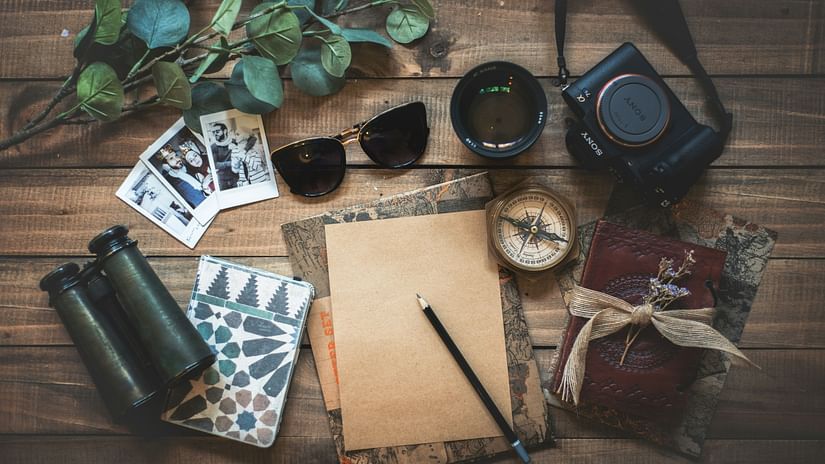 Essentials for a weekend getaway laid down on a table