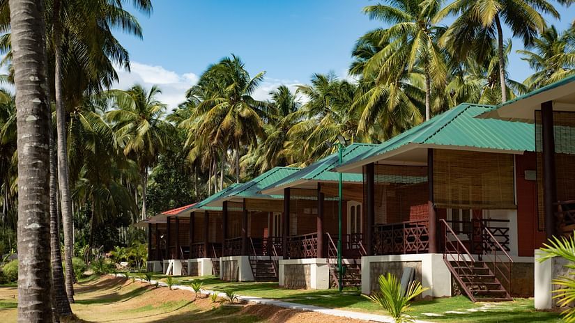 block of the Suite Rooms with coconut trees covered on the side at Ibex River Resort, Pollachi