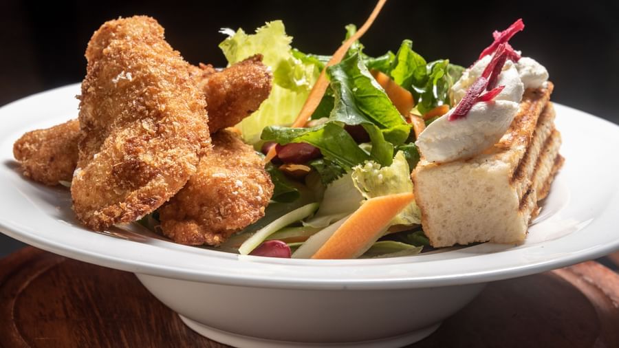 Fresh salad and crispy chicken served in a white bowl at Best Western Premier Westlands hotel restaurant.