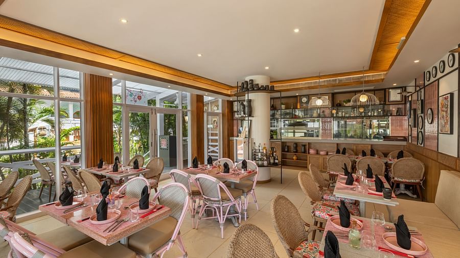 Bright and spacious restaurant interior with pink-themed décor and large windows.