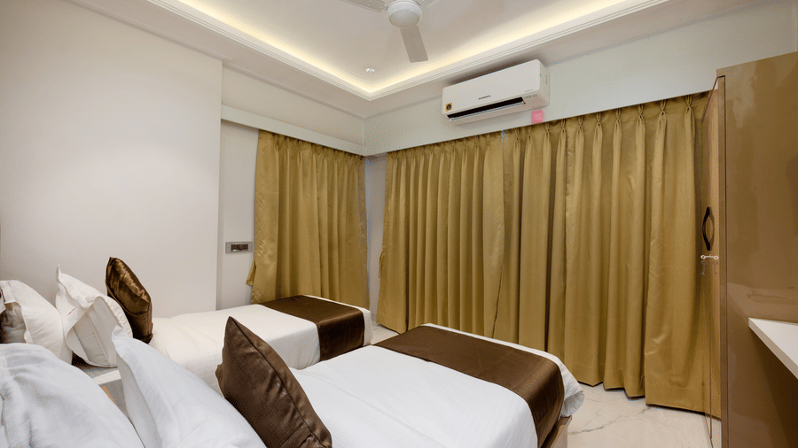 Comfortable twin bedroom with modern amenities at Home2 Residency, Mumbai Airport