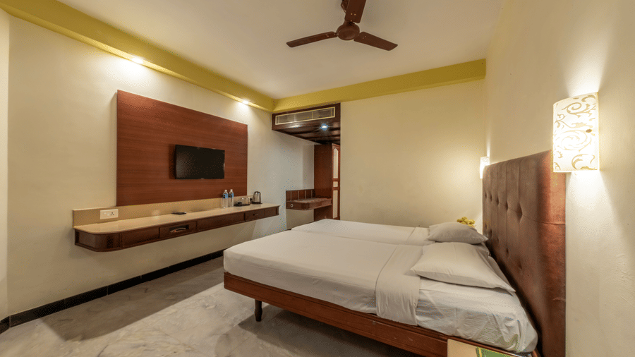 Premium guest room at Jayaram Hotel, Pondicherry with a comfortable bed, television, work desk and modern furnishings.