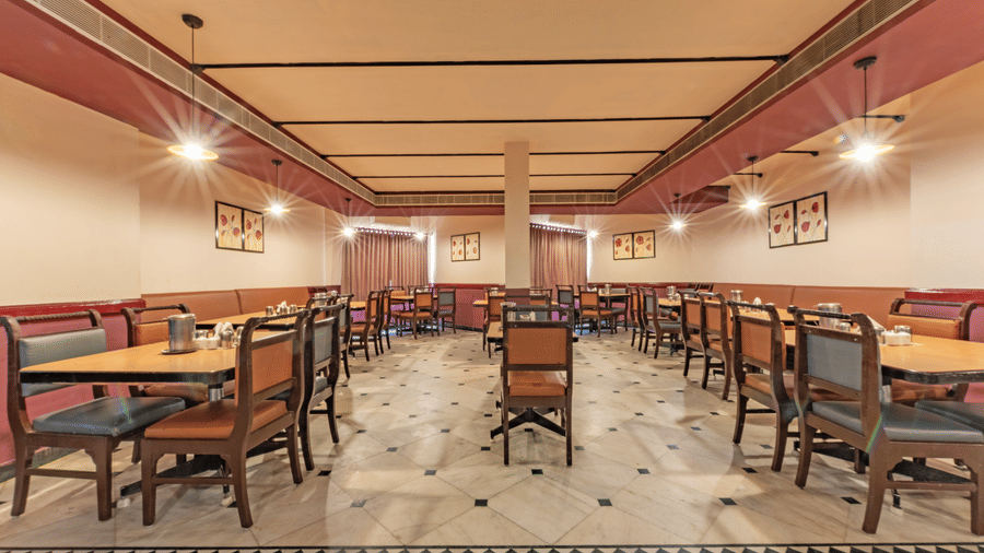 Restaurant seating at Jayaram Hotel, Pondicherry designed for relaxed dining with spacious tables and comfortable chairs.