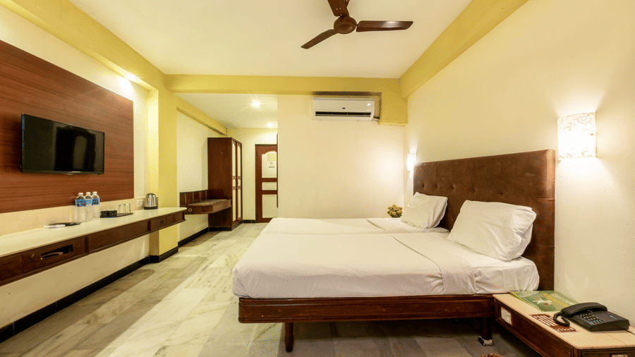 Premium guest room at Jayaram Hotel, Pondicherry with a plush bed, television, work desk and modern amenities.