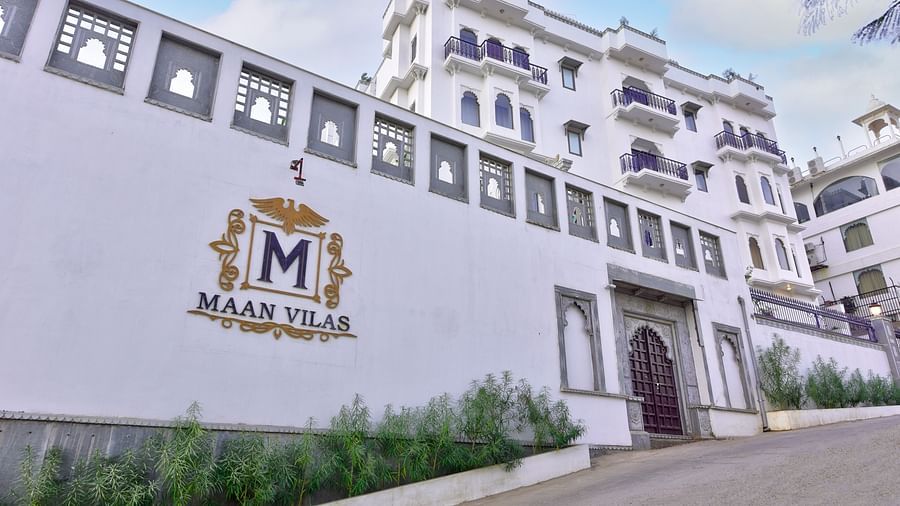 white coloured entrance of the hotel with mewar style architecture and plants outside Maan Vilas by Stonewood 