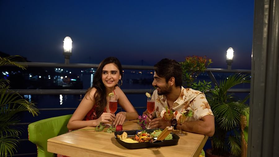 a couple enjoying food at the outdoor dining space - polo floatel kolkata