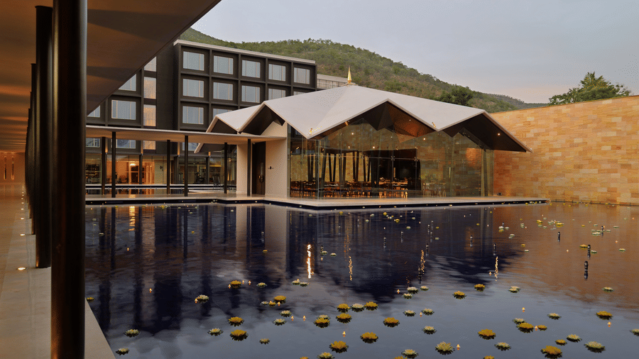 Sarovar Hotels courtyard pool area with surrounding architecture and floating floral arrangements.