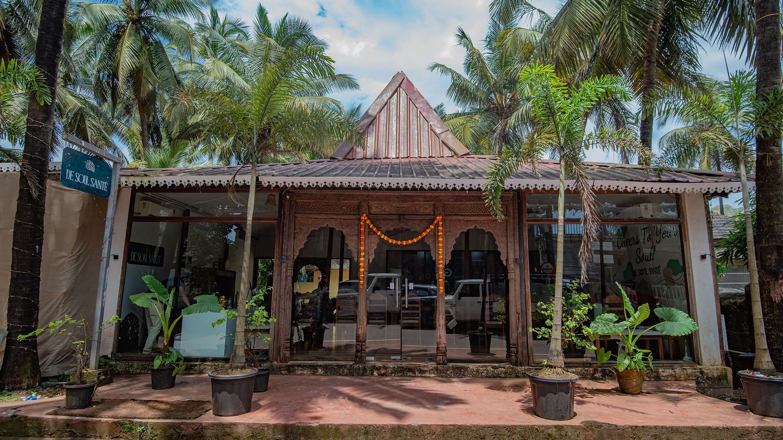 Main entrance with traditional Goan-style architecture surrounded by palm trees at De Soul Santé, Morjim