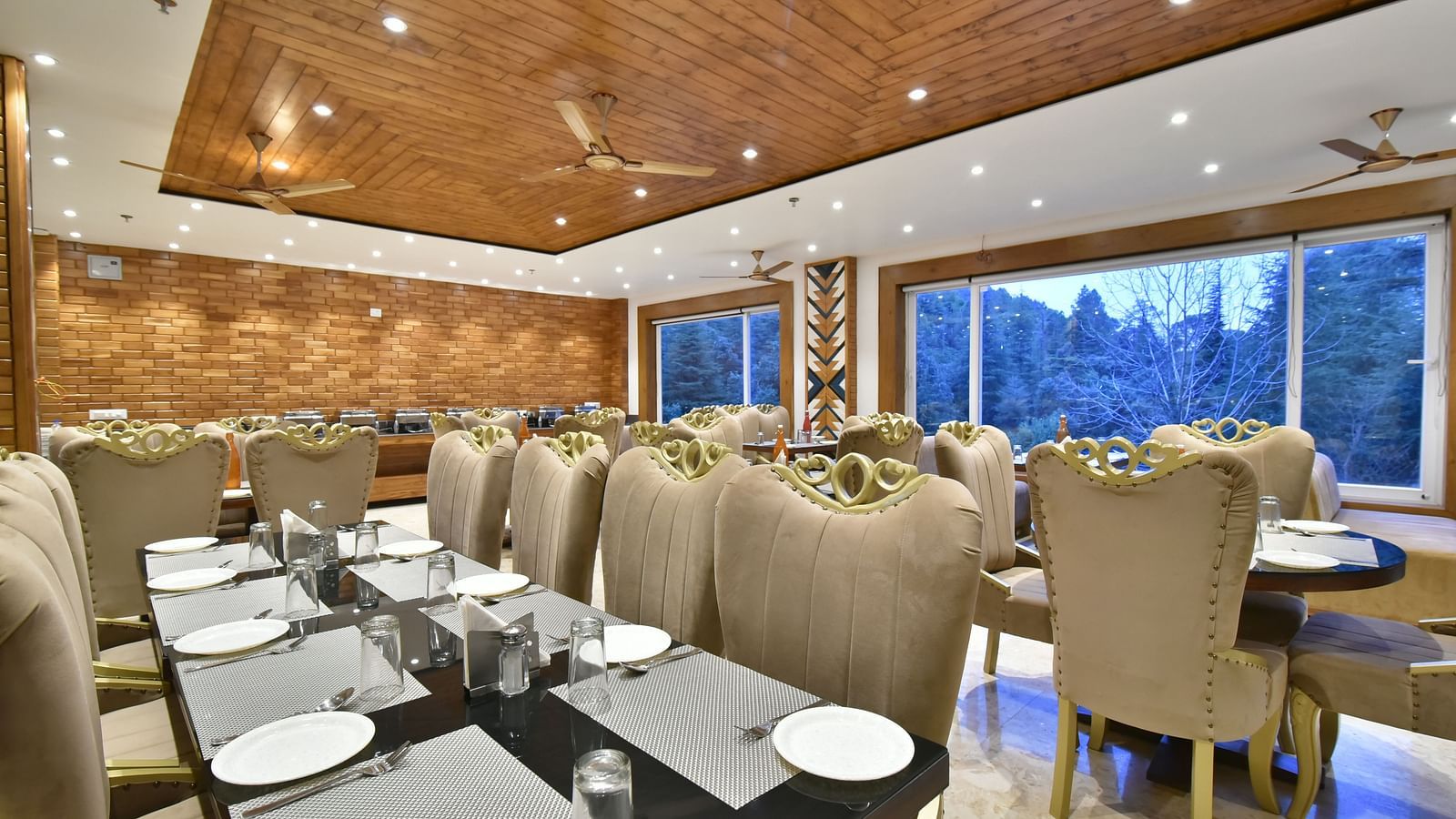 Dining area with comfortable chairs around tables at Rainbow Restaurant at DLS Ark Holiday Inn, Banikhet.