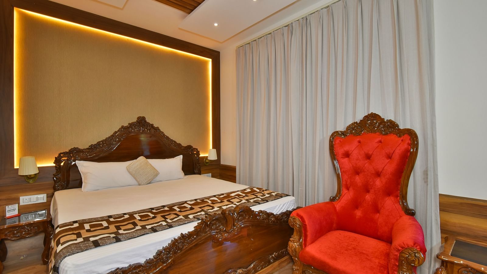 Super Deluxe room at DLS Dalhousie Valley Resort with a  king size bed, a chair and warm lighting 