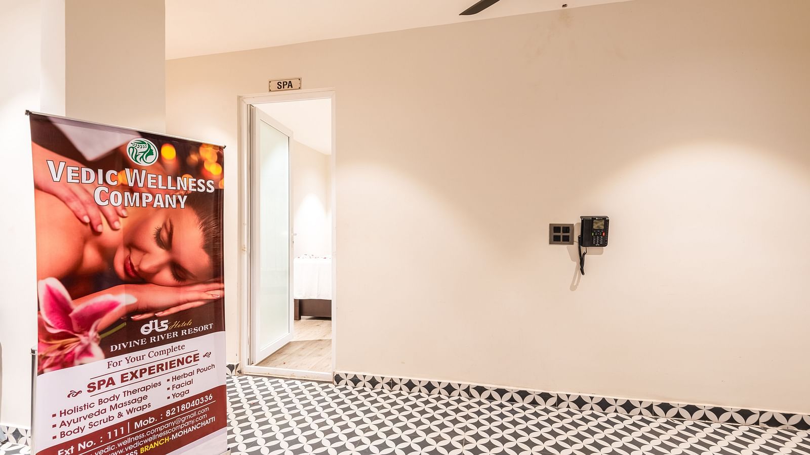 Close up view of entrance of Spa at DLS Divine River Resort and Spa with black and white floors and a banner.