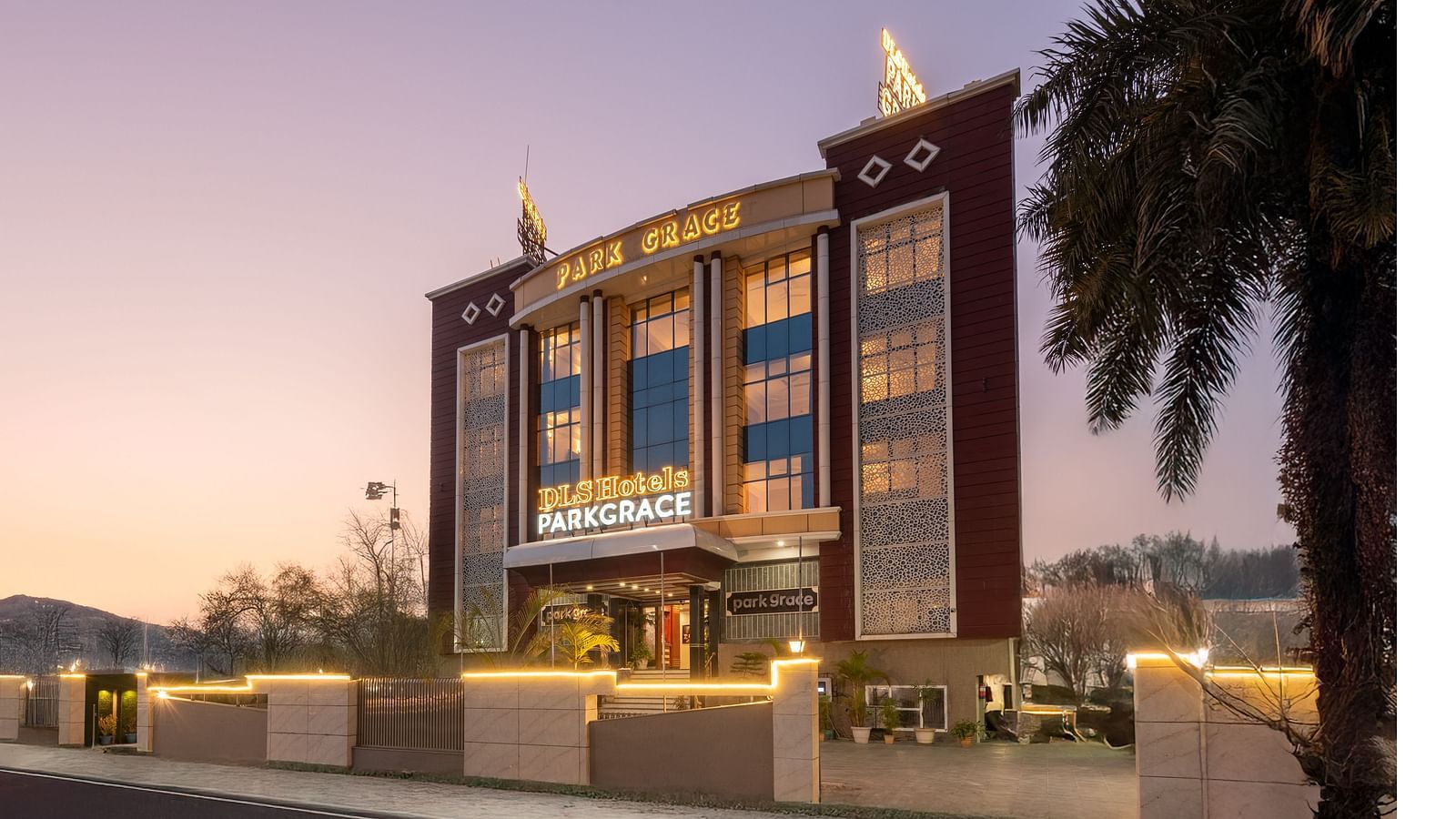 Facade of DLS Park Grace Hotel in Haridwar illuminated with warm yellow lights.
